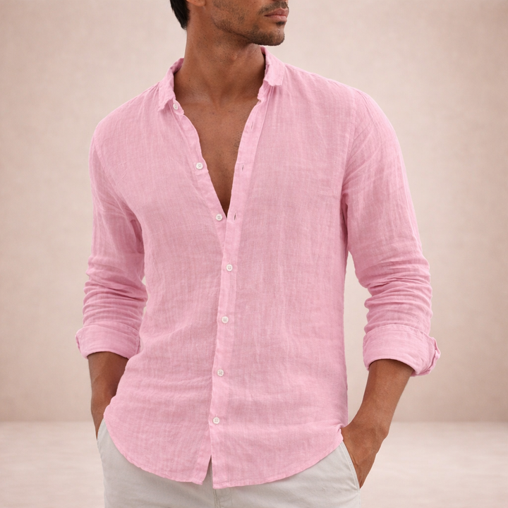Model in the pink linen shirt with hands in light pants pockets, sleeves rolled.