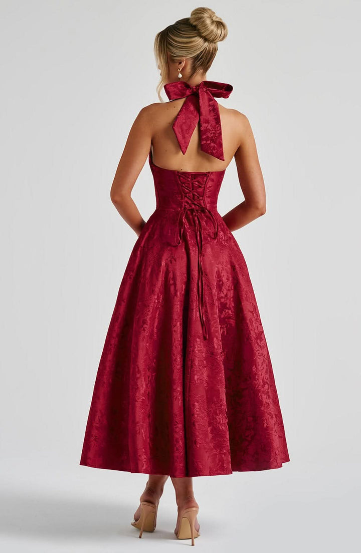 Red floral halter midi dress, back view with open back and long lace-up ties.
