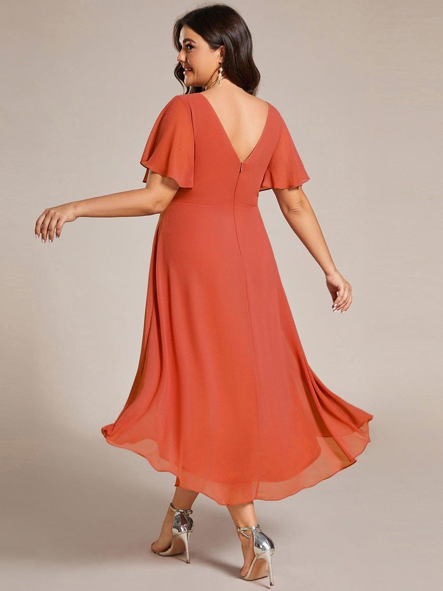 Back view of the burnt orange dress on a plus-size model, showing the V back, zipper and billowing high-low skirt. 98