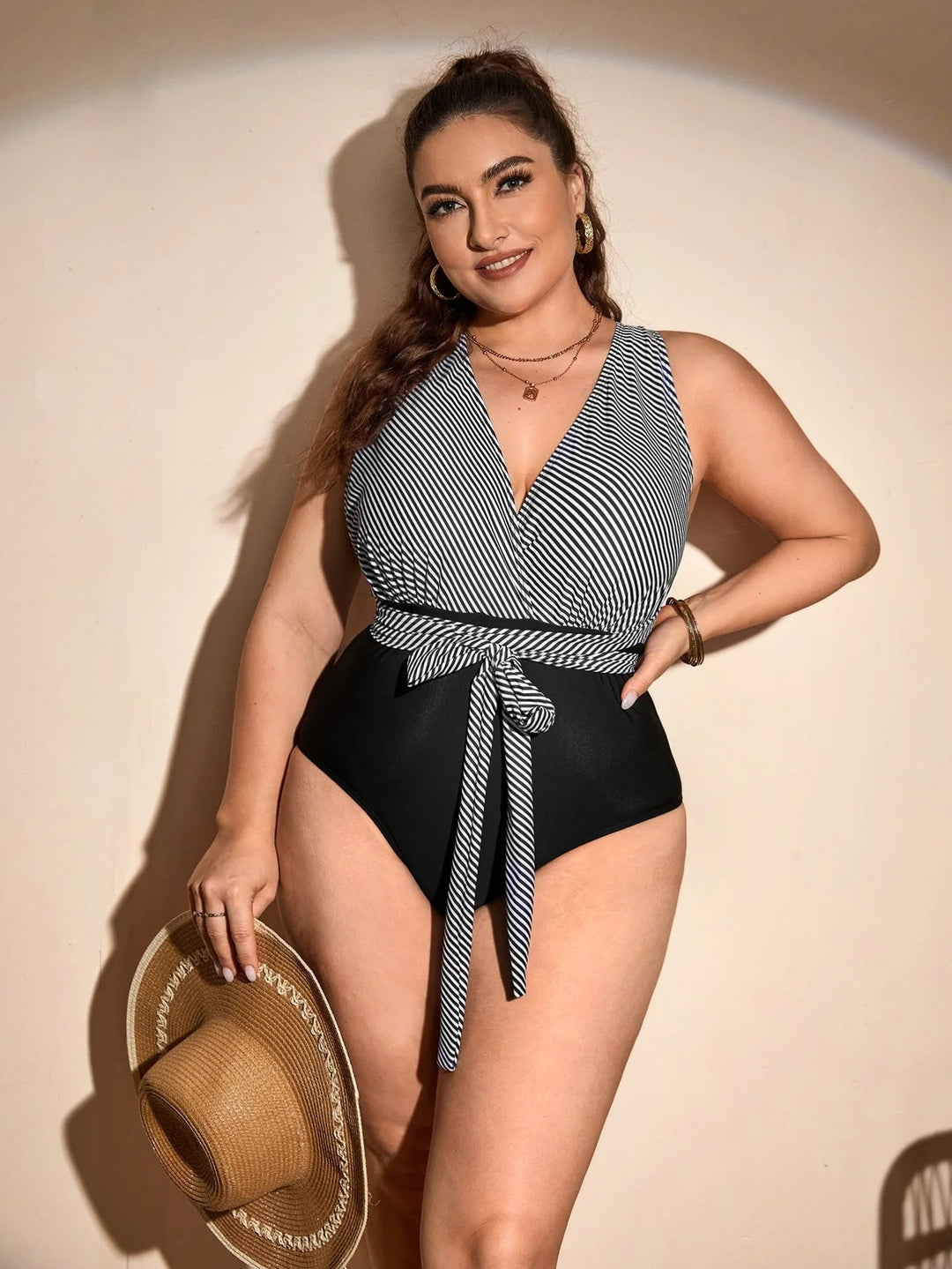 Frau im gestreiften Badeanzug mit Strohhut, Plus-Size-Mode, Sommerkleidung, schwarz-weiß.