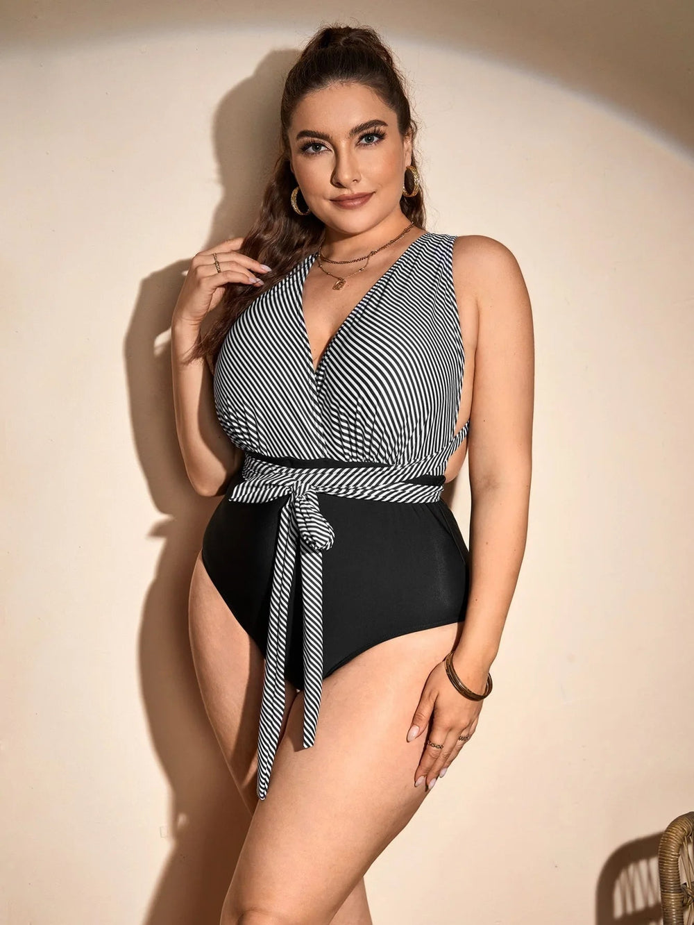 Frau im gestreiften Badeanzug, schwarz-weiß, Plus-Size, elegantes Design, Sommermode.