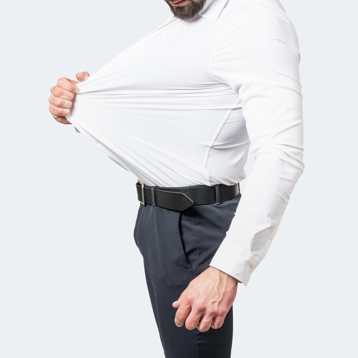 Men's white stretch dress shirt tucked into navy trousers, detail view.