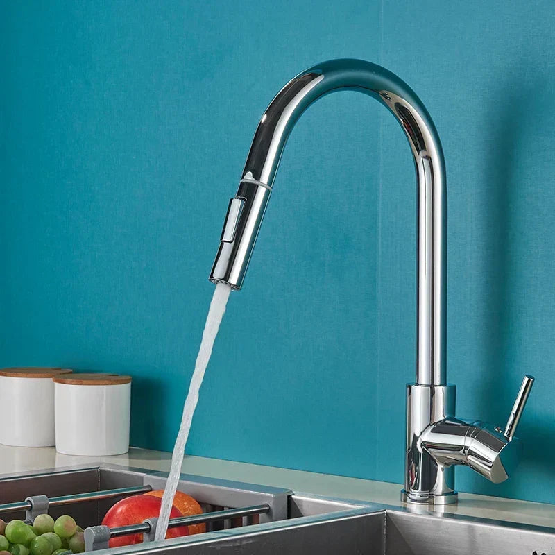 Chrome gooseneck faucet running water into a sink against a teal wall, fruit in a rack below 1