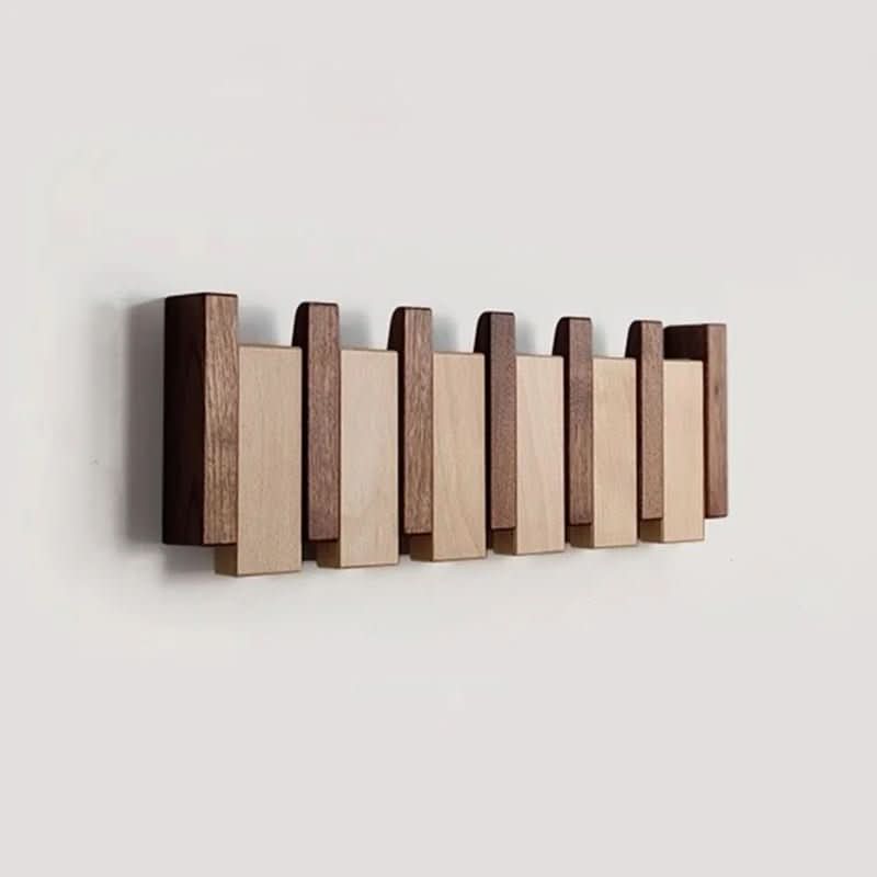 Brown wooden piano-style wall coat rack, another view with staggered slats on a light wall.