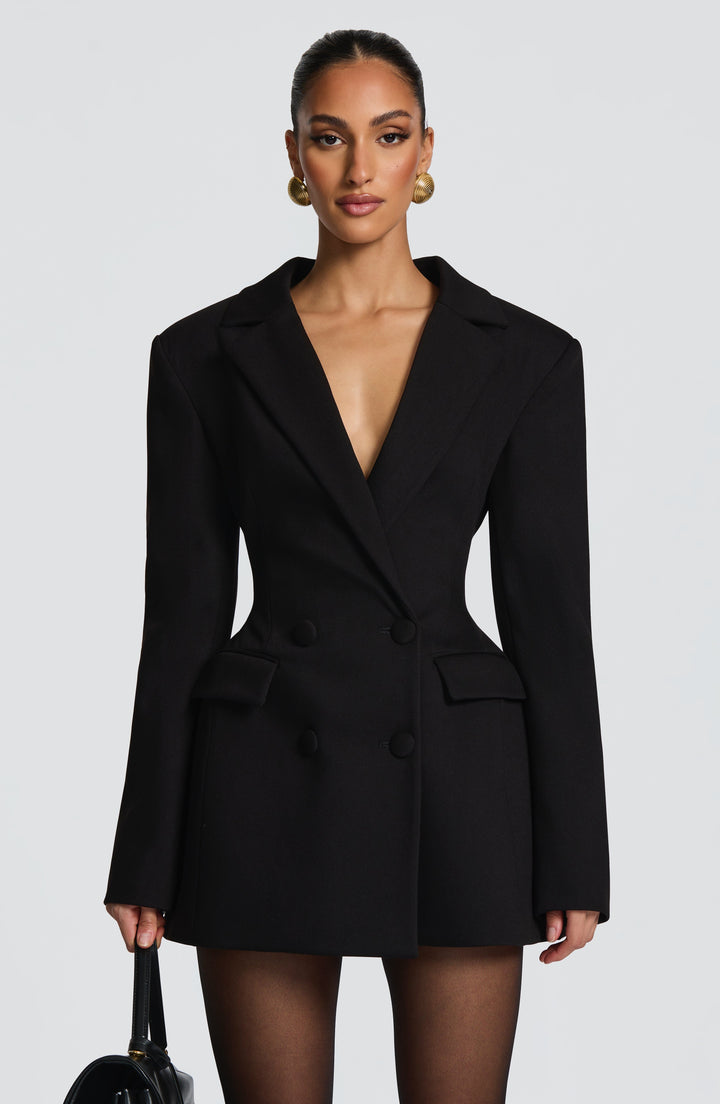 Black double-breasted blazer mini dress with a deep neckline and flap pockets, detail.