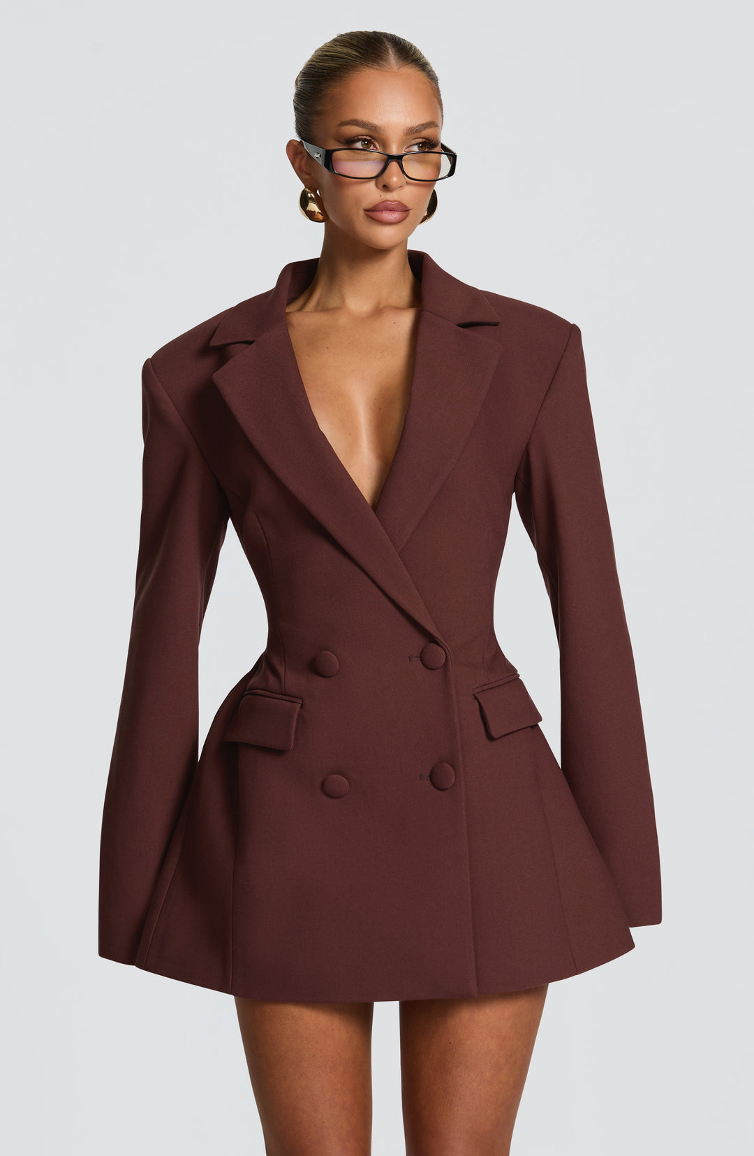 Brown double-breasted blazer mini dress with a deep plunging neckline and flap pockets.