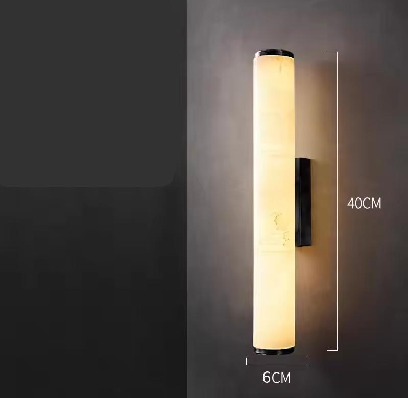 Shorter version of the lit marble tube sconce on a dark wall, with dimension lines showing 40 cm height and 6 cm width. 22