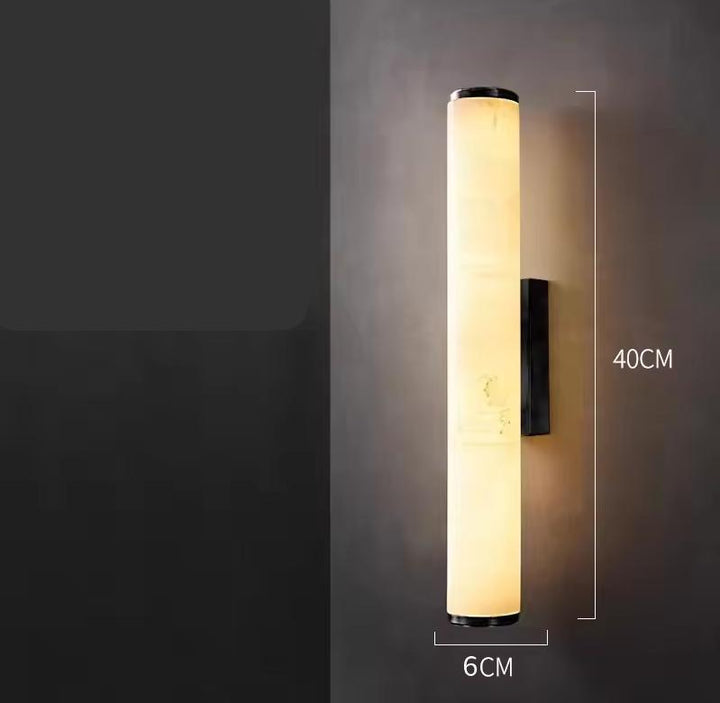 Shorter version of the lit marble tube sconce on a dark wall, with dimension lines showing 40 cm height and 6 cm width. 22