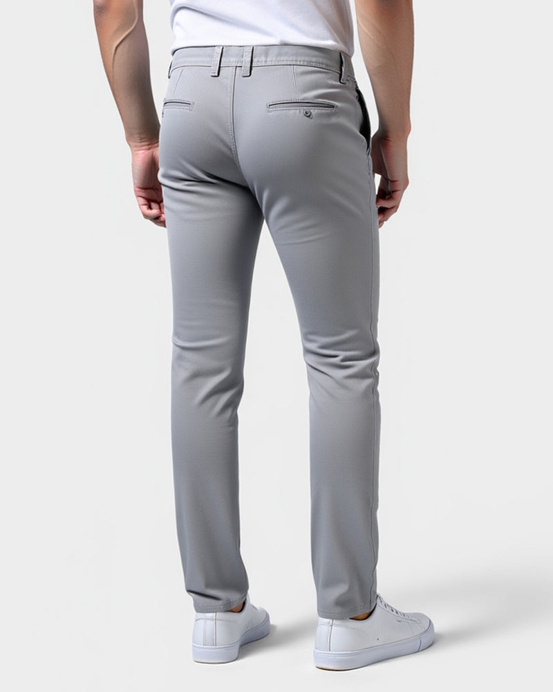 Back view of light gray chinos showing two buttoned welt back pockets and belt loops, worn with white sneakers. 3