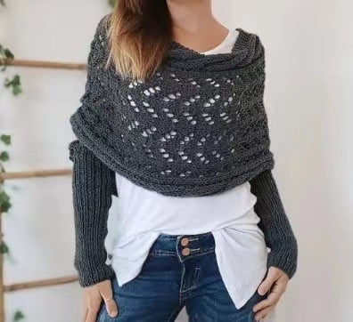 Close front view of the dark gray wrap, showing the openwork zigzag lace pattern and ribbed sleeves over a white shirt. 3