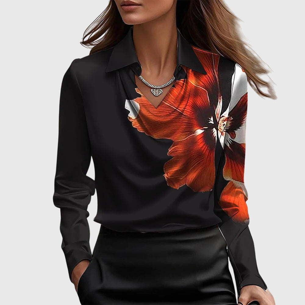 Model wearing the black satin blouse with a large red and white flower print across one shoulder and chest, plus collar and cowl neck.