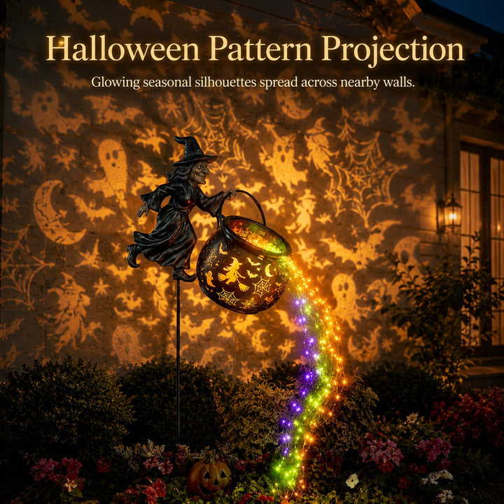 The cauldron light glowing in front of a house wall with projected ghosts, bats, moons and spiderwebs.