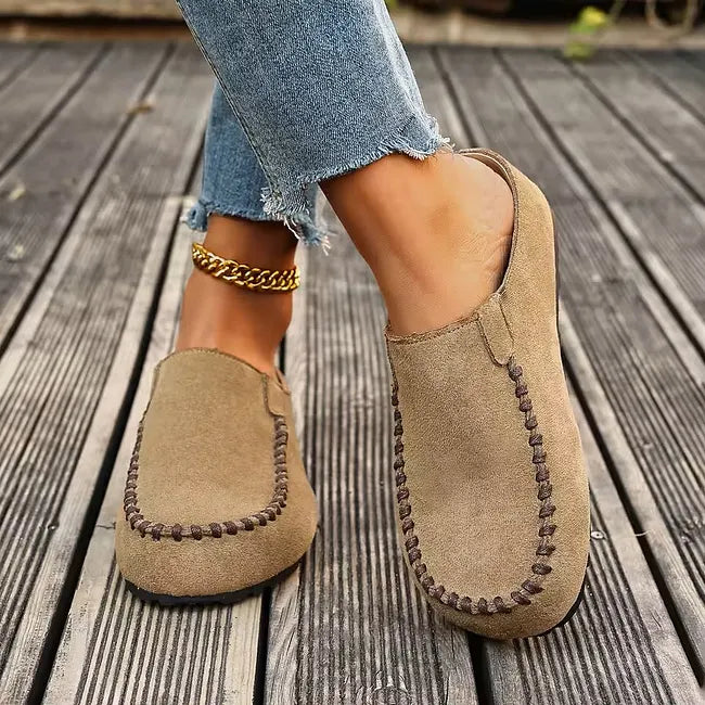 Brown leather slip-on sandals with dark stitching, another view.