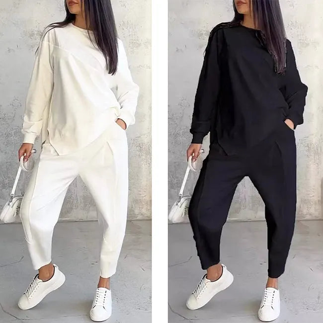 Side-by-side comparison of the white and black versions of the sweatshirt and joggers, both worn with hand in pocket and white sneakers.