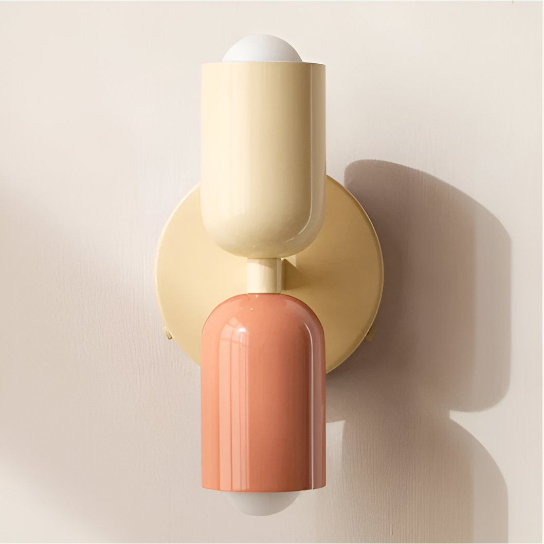 Close-up of a cream and peach wall light with a cream backplate, casting soft shadows on the wall. 37