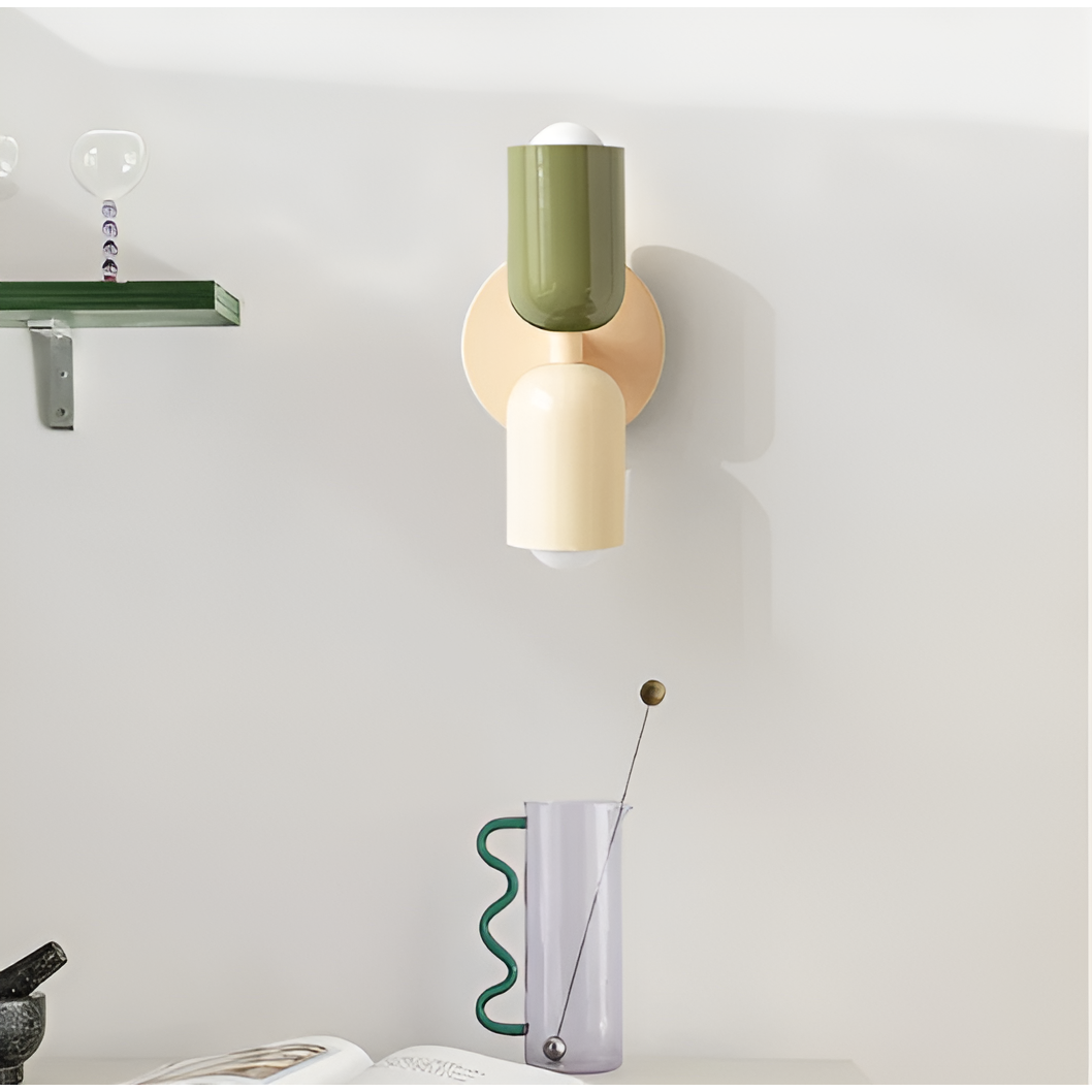 Green and cream wall light mounted on a wall in a styled room, beside a shelf and a glass pitcher. 35