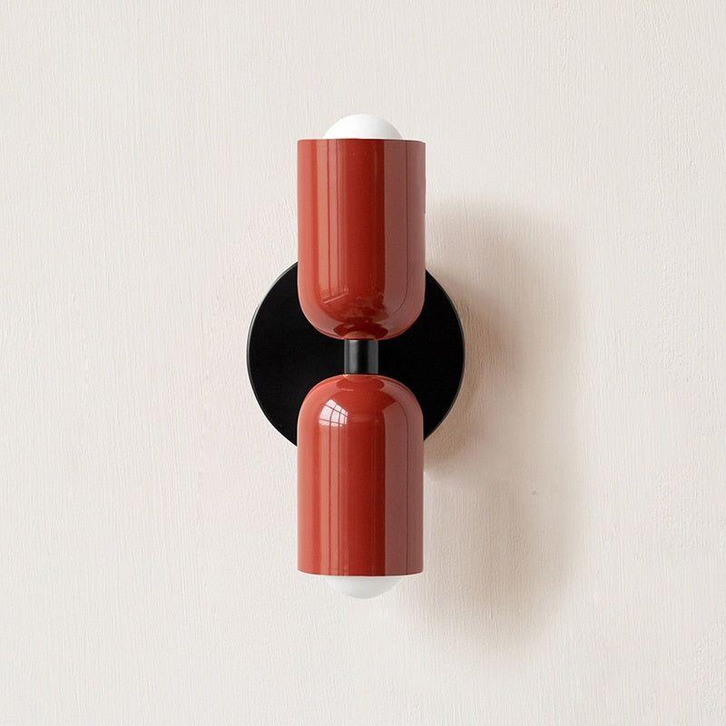 Wall light with both heads in glossy red on a black round backplate. 8