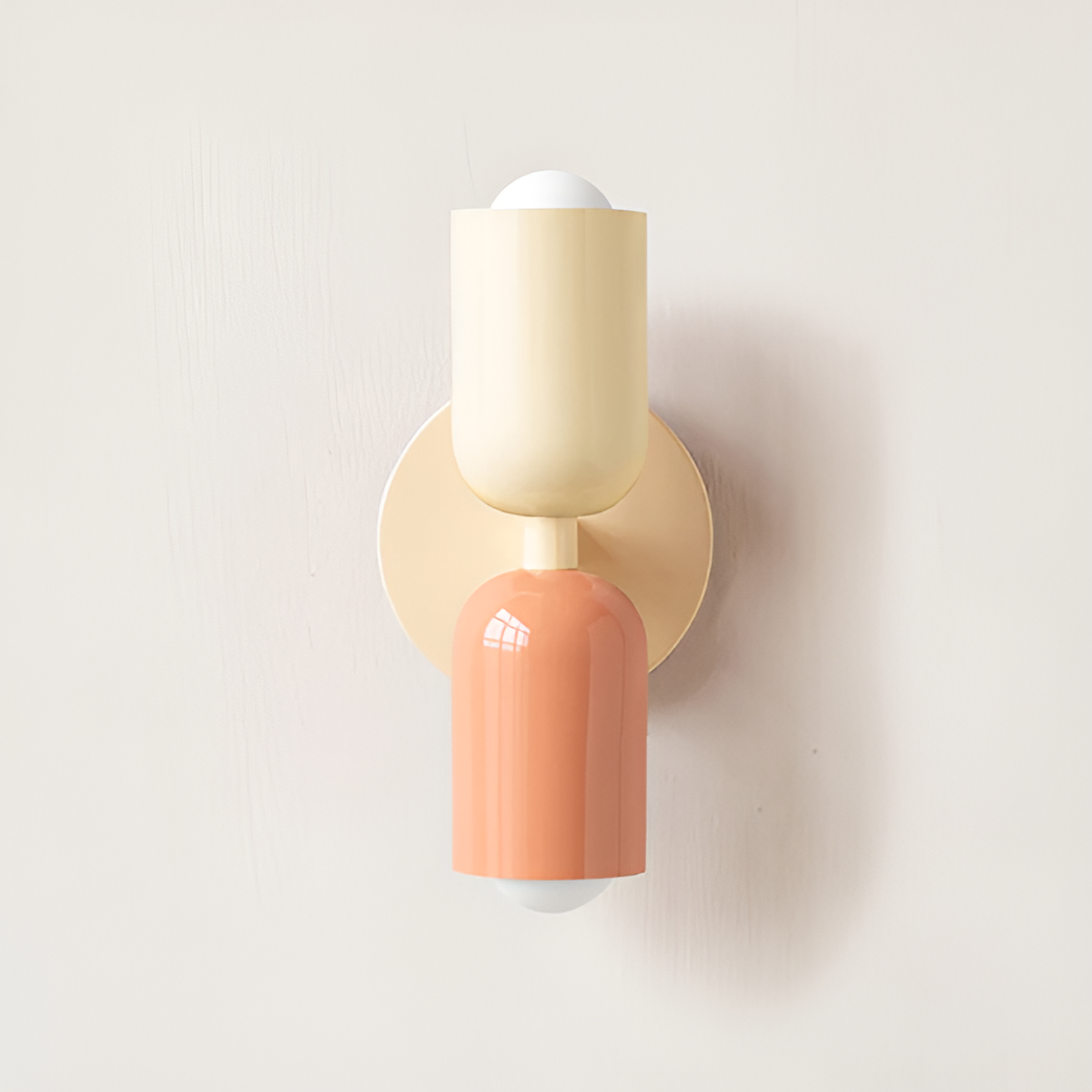 Wall light with a cream upper head, peach lower head and a cream round backplate and stem. 24