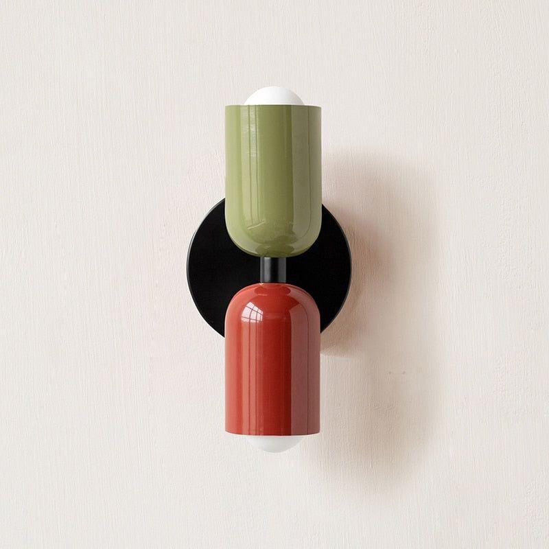 Wall light with a green upper head and red lower head on a black round backplate. 11