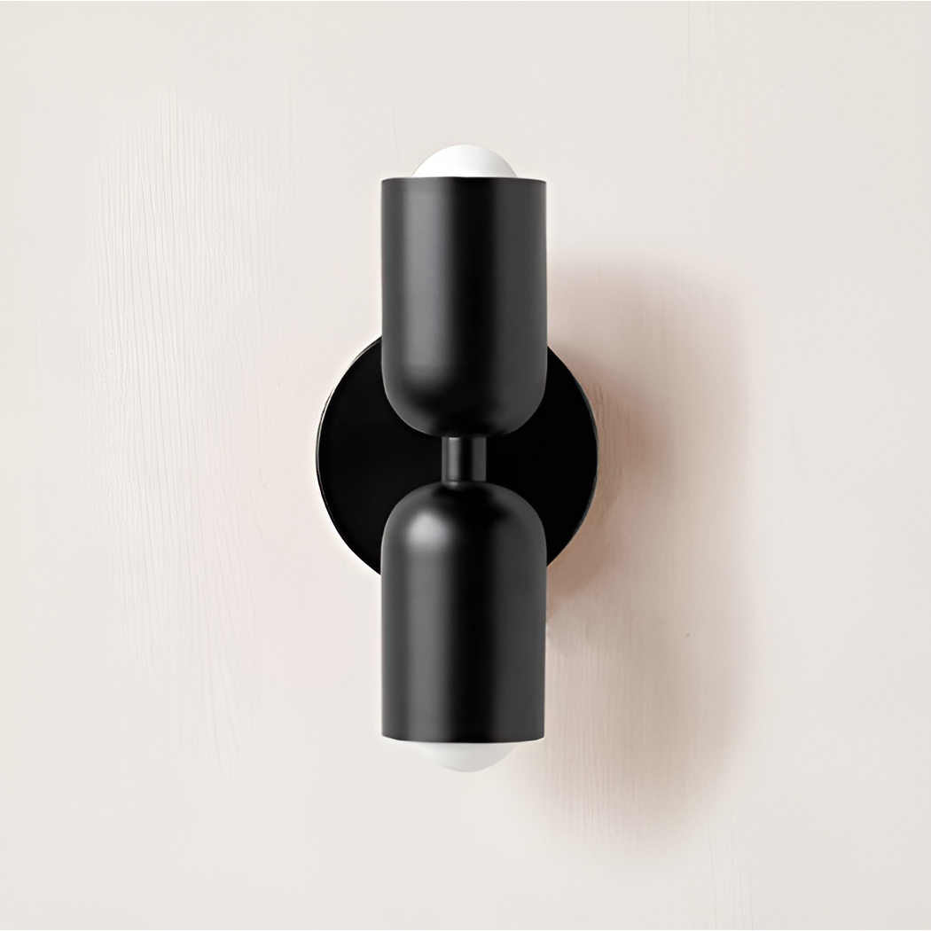 All-black wall light with two heads, a black stem and a round black backplate. 27