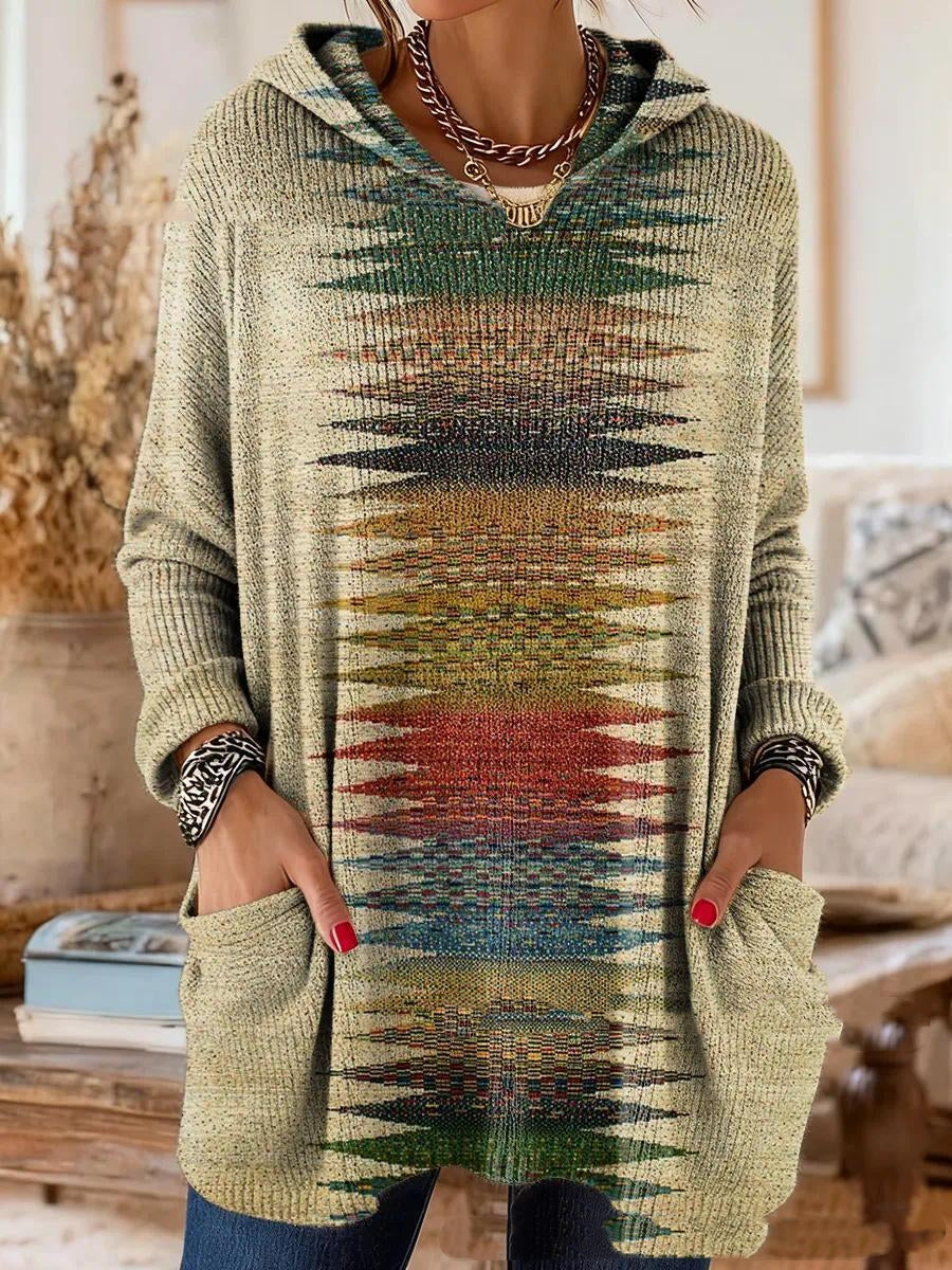 Model wearing the hooded tunic in a soft beige knit with a vertical multicolor geometric zigzag stripe down the center. 5