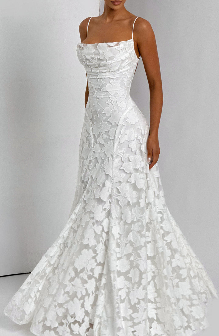 Elise Gingham Dress in white with the skirt flared wide and a raised floral texture, angled view.