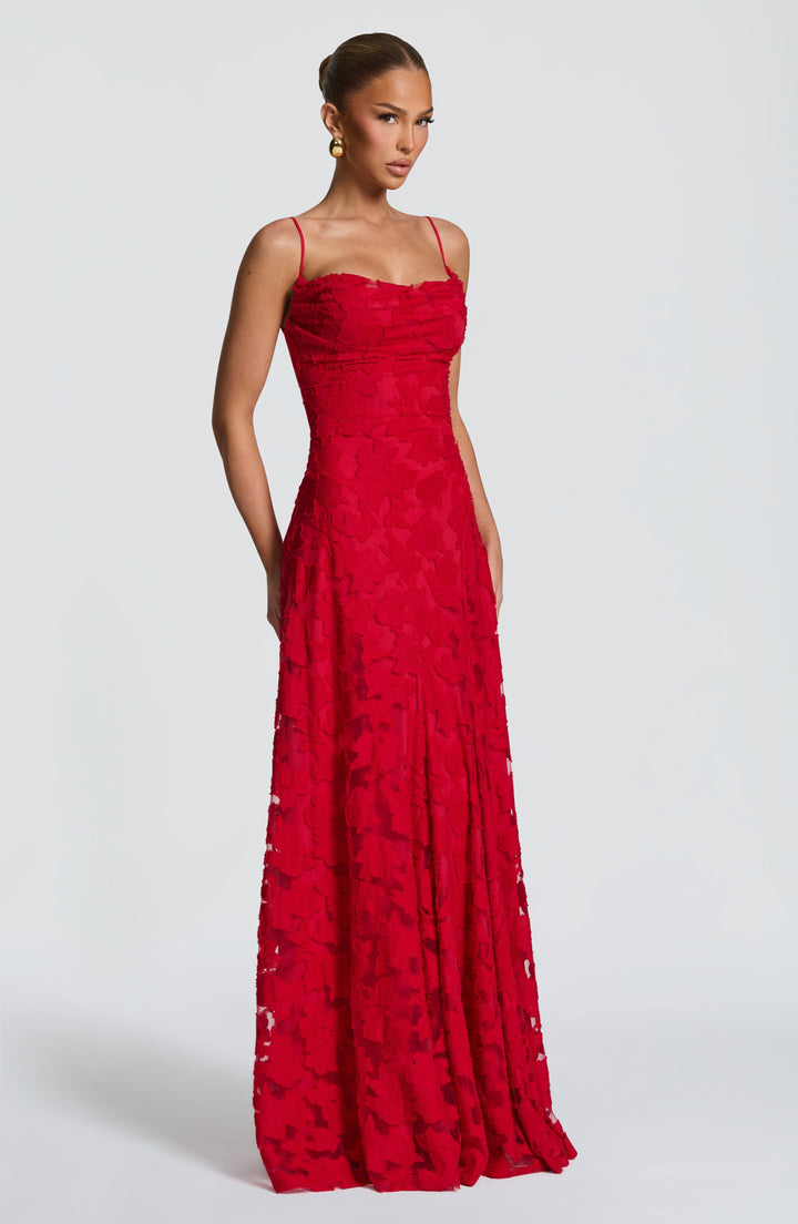 Three-quarter front view of the red textured floral gown on a model, showing the fitted bodice and sheer panels in the skirt. 25