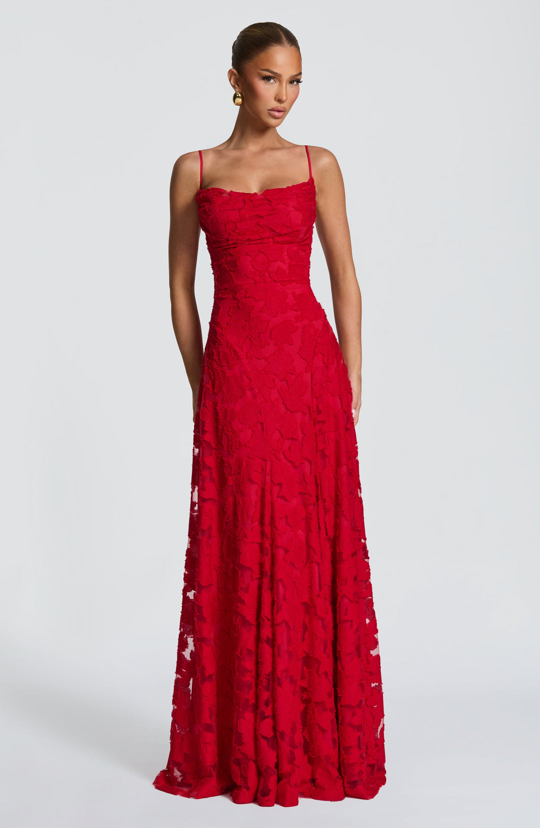 Front view of the red floral jacquard maxi gown with a draped neckline, thin straps and a long flowing skirt. 24