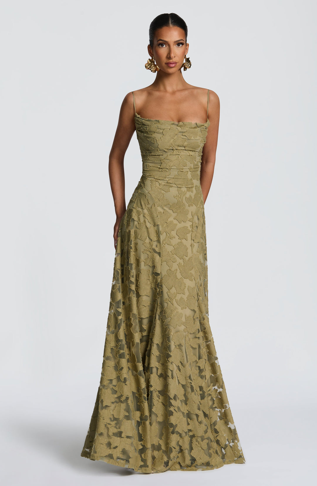 Front view of the olive green floral jacquard maxi gown with thin straps, a cowl neckline and sheer lower skirt. 29