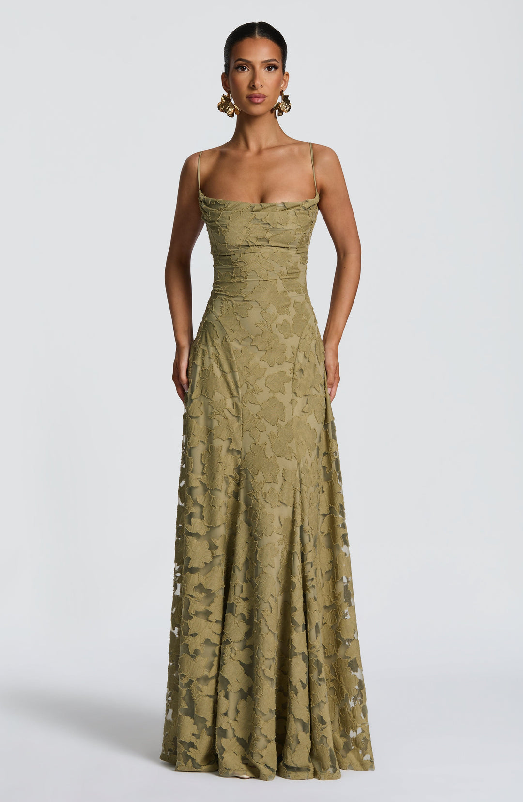 Straight-on view of the olive green floral gown with a model's arms at her sides, showing the paneled fitted bodice. 32