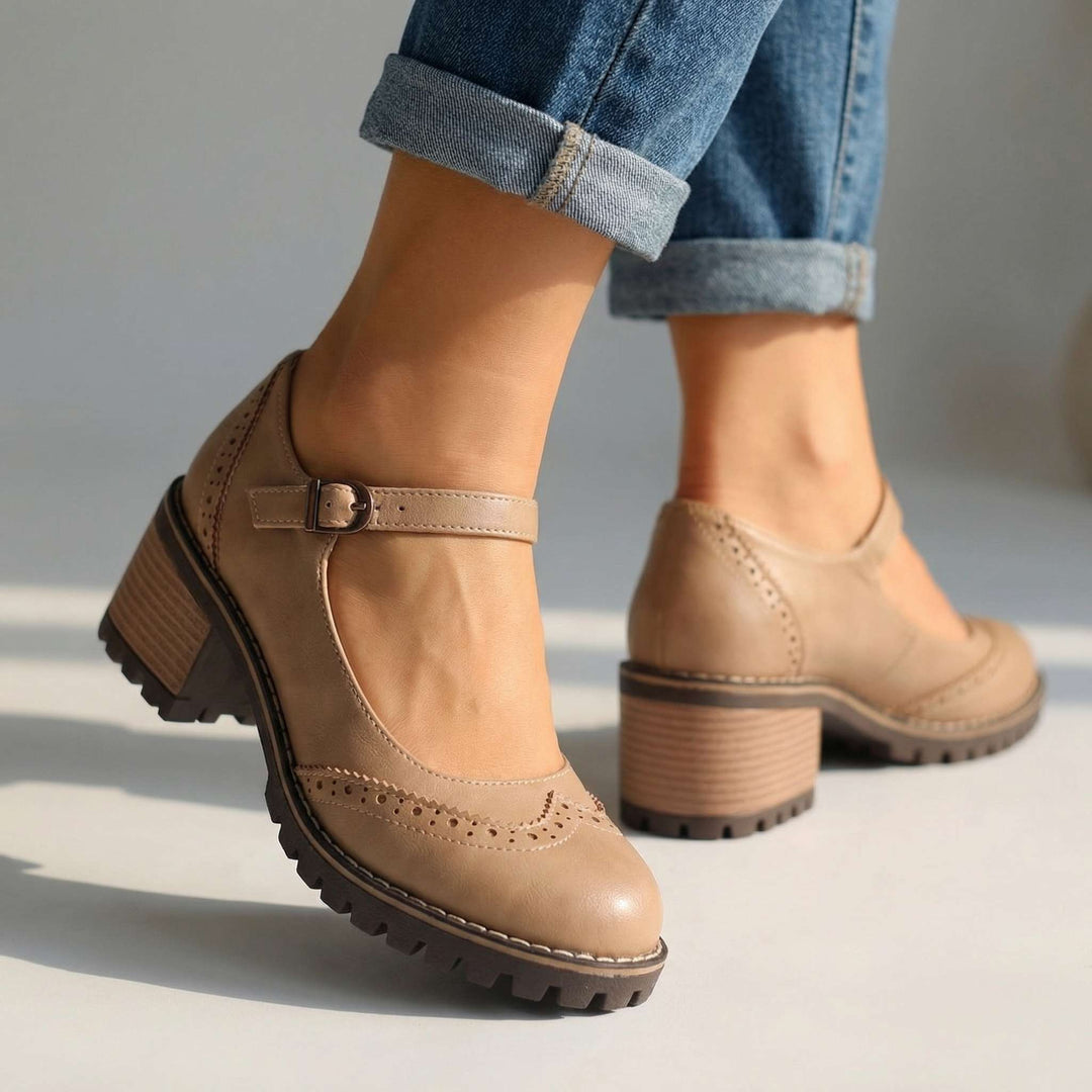 Beige brogue Mary Janes with a buckle and stacked block heel.