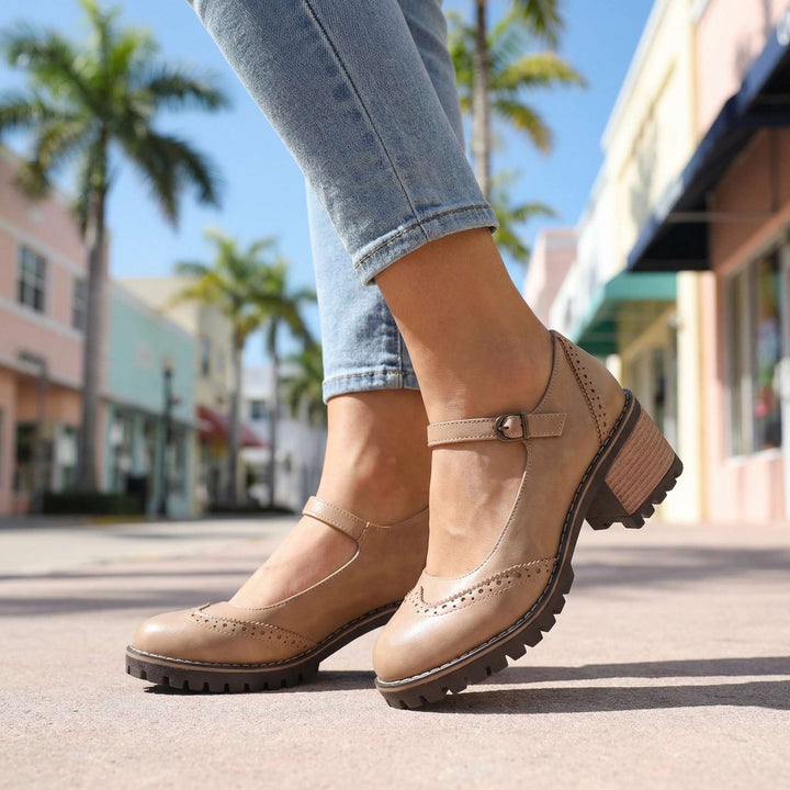 Beige pair worn on a sunny street, low-angle view showing the strap, brogue toe and lugged sole 9