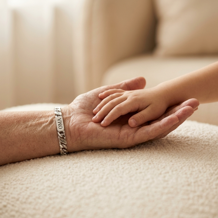 Silver-tone engraved chain bracelet on a woman's wrist holding a child's hand