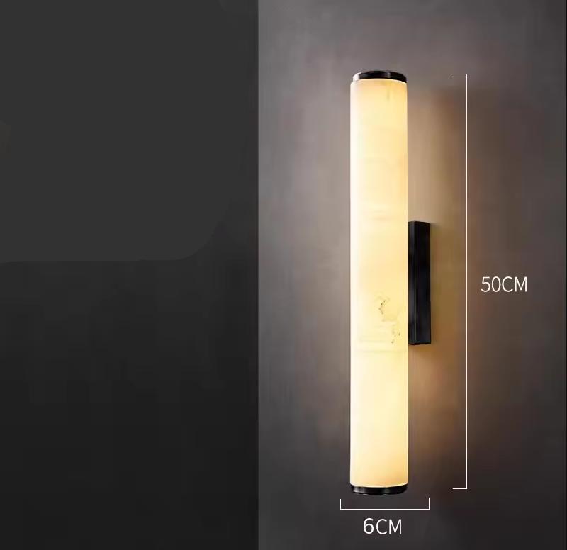 Lit cylindrical marble wall sconce on a dark gray wall, with dimension lines marking its 50 cm height and 6 cm width. 21