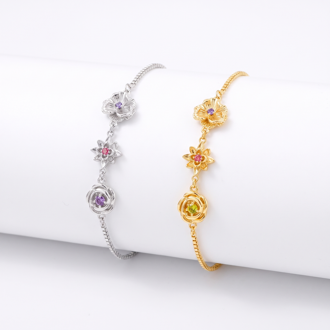 Silver and gold birth flower bracelets with three flower charms, shown side by side.