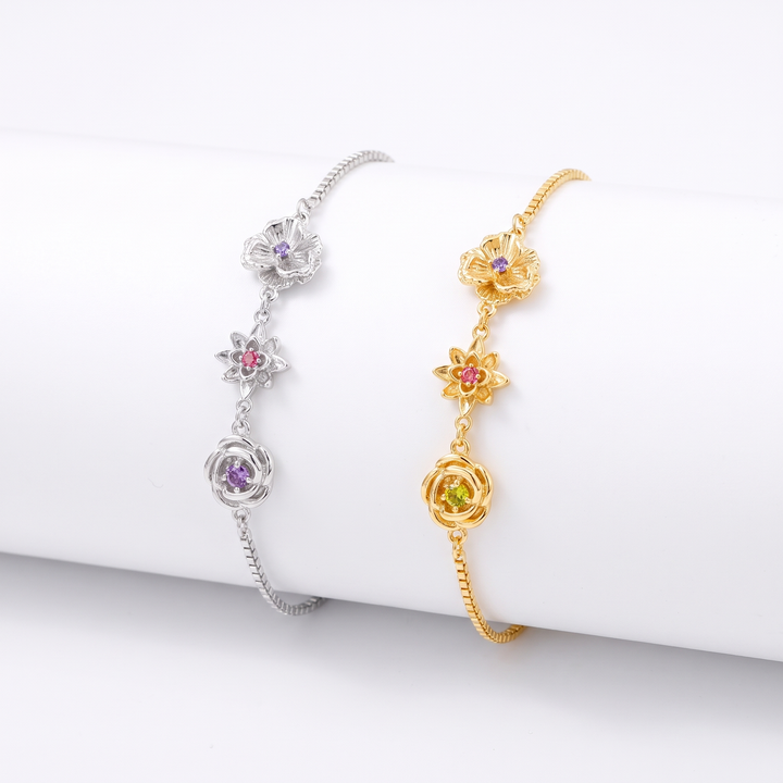 Silver and gold birth flower bracelets with three flower charms, shown side by side.