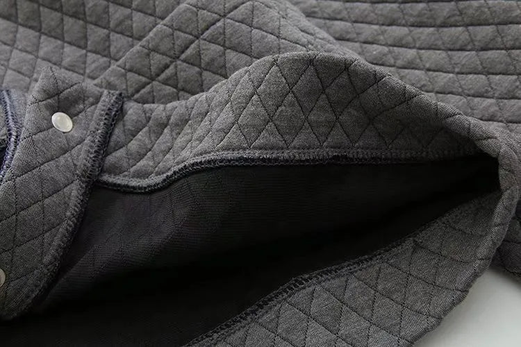Grauer gesteppter Stoff, weiche Textur, ideal für Bekleidung, Heimtextilien, hochwertig.