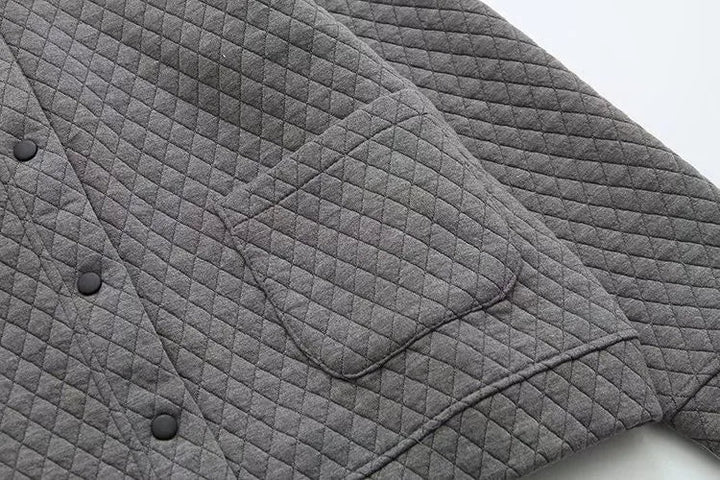 Graue gesteppte Jacke mit Knopfleiste und Tasche, modisch, warm, aus Baumwolle.