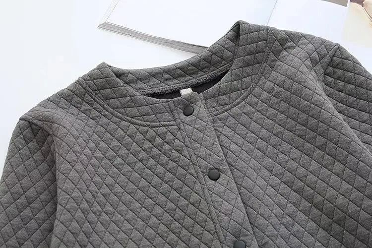 Graue gesteppte Jacke mit Rundhalsausschnitt und Druckknöpfen, modisch und warm.
