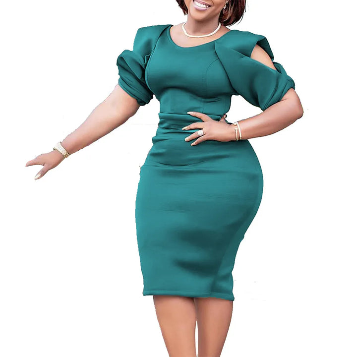 Frau in elegantem, grünem Kleid mit Puffärmeln, knielang, modisch, festlich.