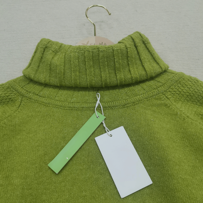 Grüner Rollkragenpullover aus Wolle, Damenmode, mit Etikett, auf Kleiderbügel.