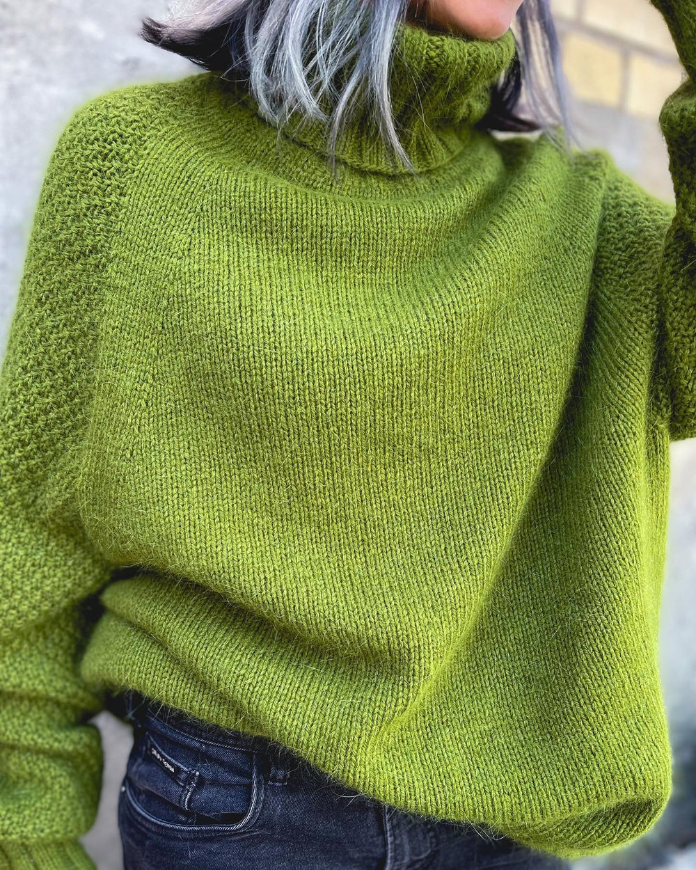 Frau in grünem Strickpullover mit Rollkragen, lässig, modisch, Herbstmode, gemütlich.