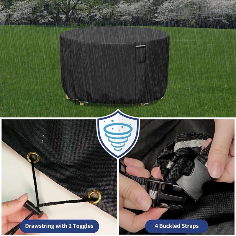 Black round patio furniture cover on a rainy lawn with the drawstring and buckle strap details.