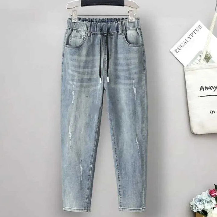 Hellblaue Jeanshose mit elastischem Bund, Kordelzug und Taschen, lässiger Stil für Damen.