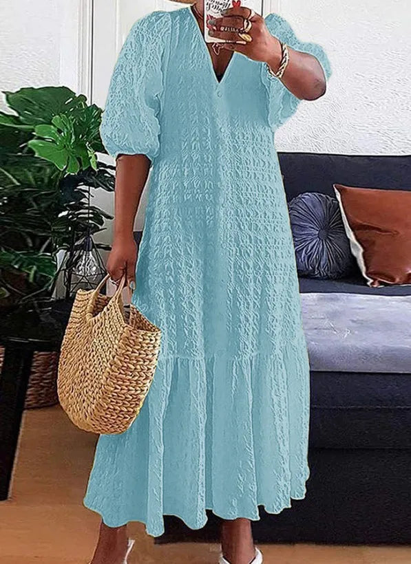 Frau in hellblauem Sommerkleid mit Strohtasche im Wohnzimmer, moderne Mode, Freizeitkleidung.