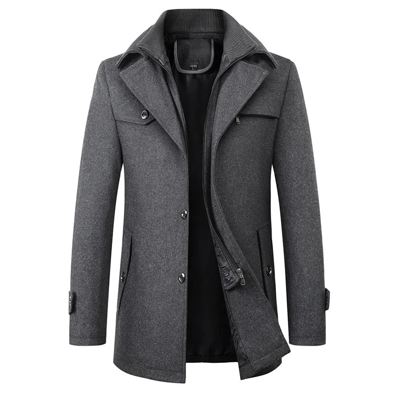 Front view of the gray version of the coat, showing the double collar, buttoned flap pocket and zip-through inner layer partly open. 2