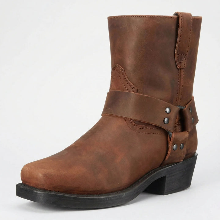 Brown leather mid-calf boot with a studded harness strap and square toe, shown at a three-quarter angle on a light background. 2