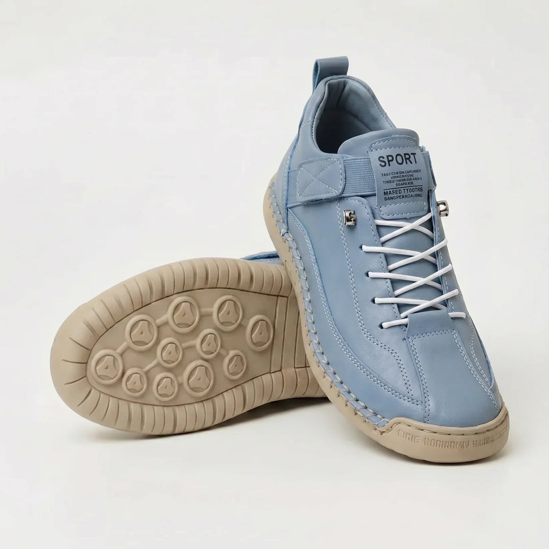 Light blue sneakers with white elastic laces and a beige sole, one shoe standing and one showing the tread 11