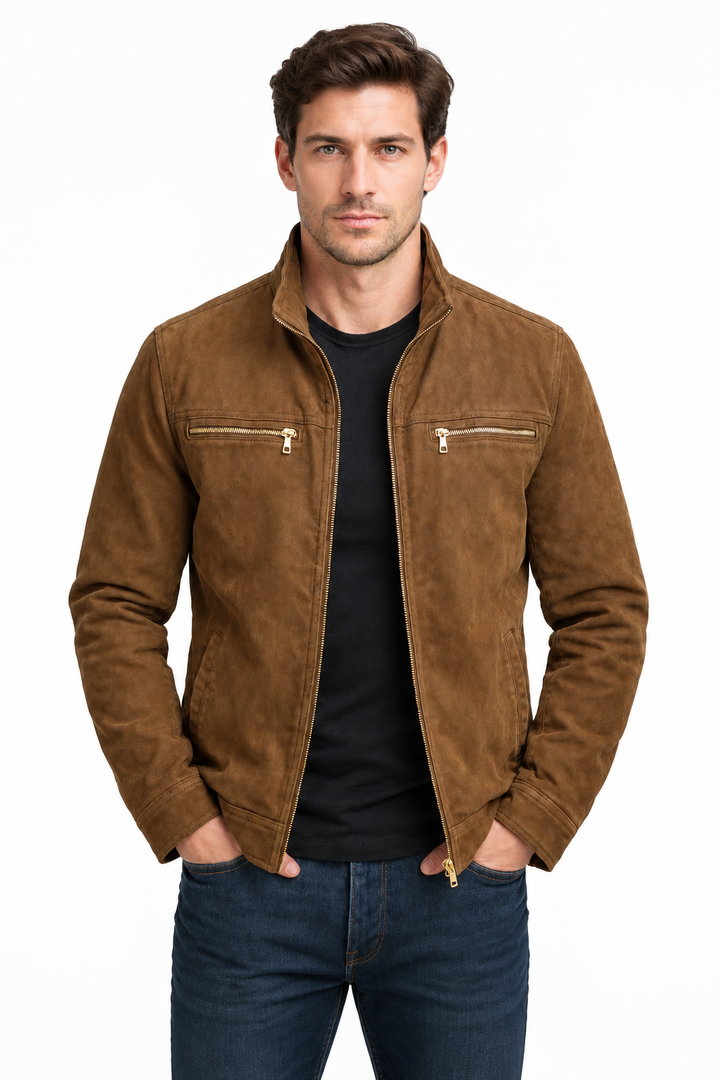 Man against a white background wearing the brown jacket with gold zippers over a black tee and jeans.