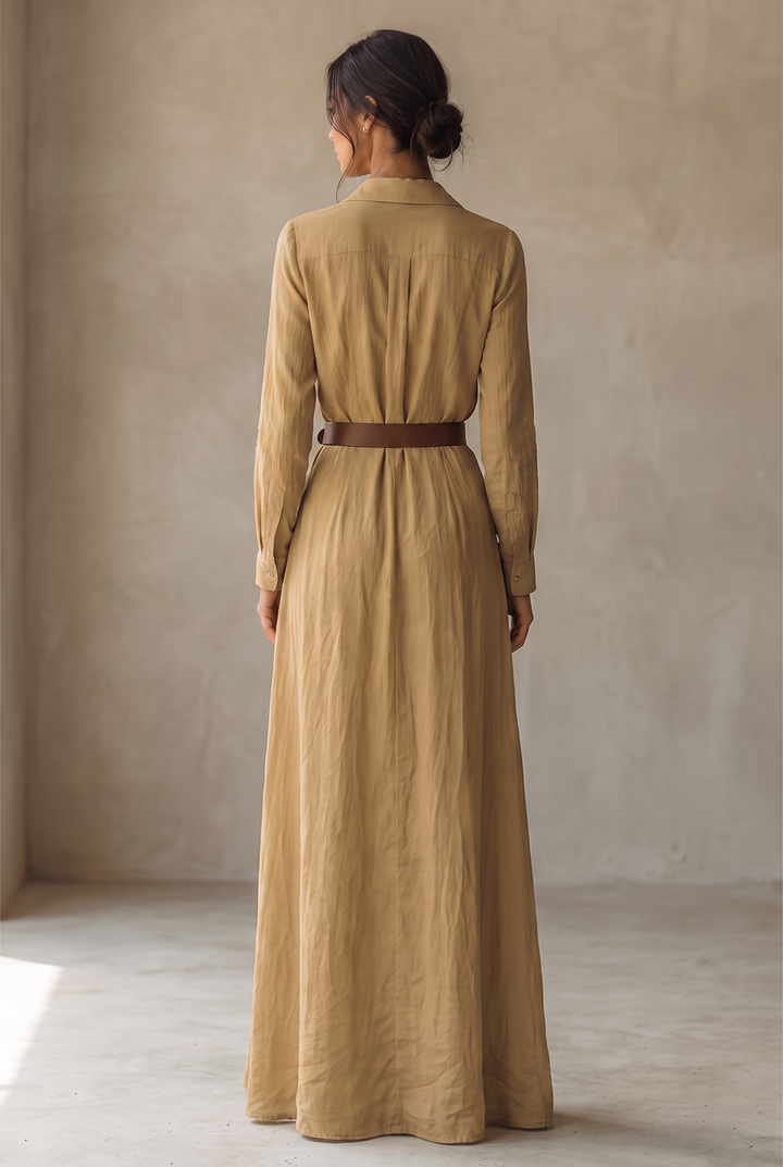 Back view of the yellow maxi dress showing the yoke seam, buttoned cuffs, brown belt and long flowing skirt.